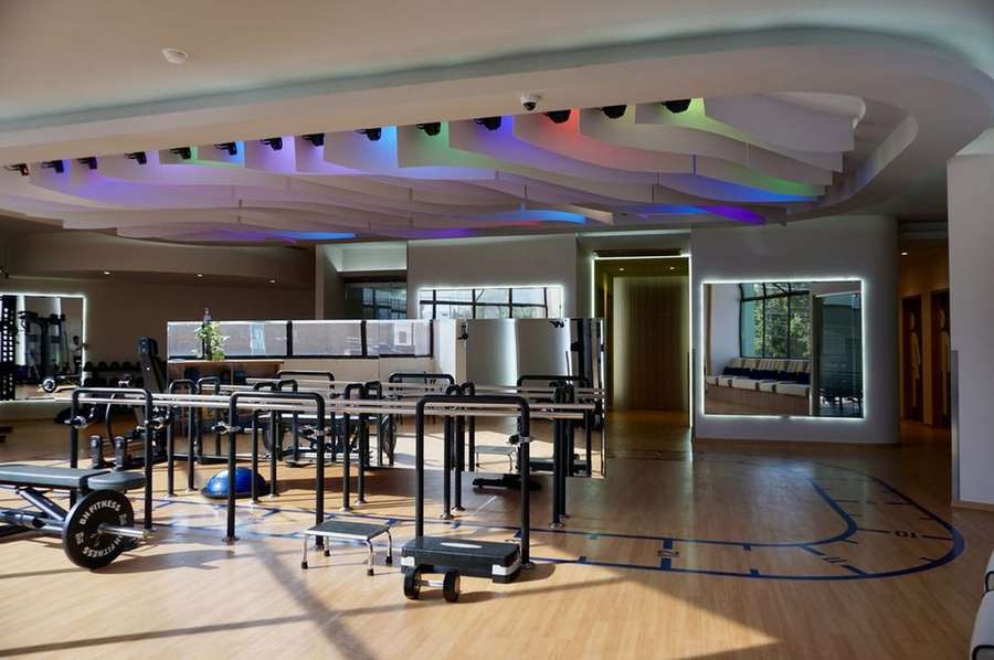Área de rehabilitación con barras paralelas, pesas y equipo funcional